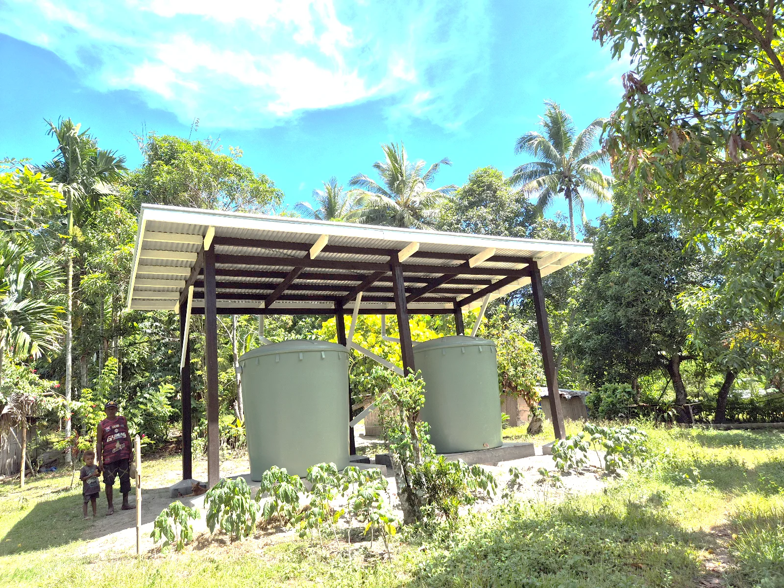 Two rainwater tanks beneath a roofed collection structure.